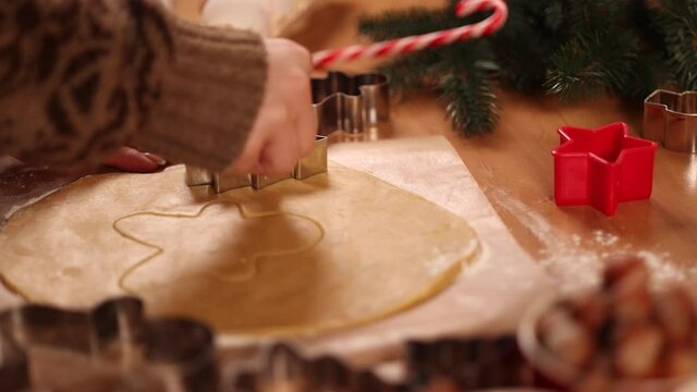 Woman making gingerbread at home. Female cutting cookies of gingerbread dough. Christmas and New Year traditions concept. Christmas bakery. Happy hollidays