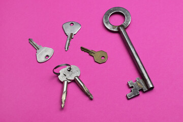 Keys on pink background, trendy colorful photo with colored paper.