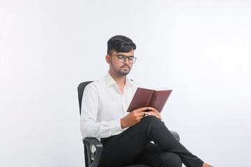 Young Indian male reading Diary over white background.
