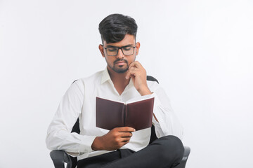 Young Indian male reading Diary over white background.