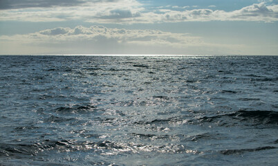 Summer sea background. Texture of water surface. Shining blue water ripple pattern.