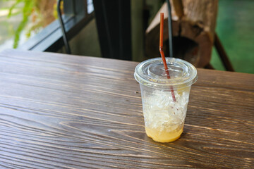 empty plastic cup of Thai milk ice tea with green straw 