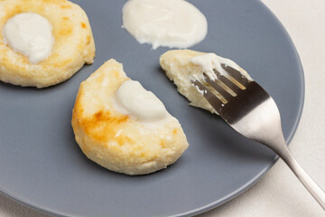 Piece of cottage cheese pancake on fork on gray plate