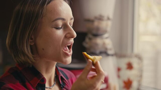 Young woman testing fresh keto bread. Close-up slow motion shot. Woman bite homemade bread