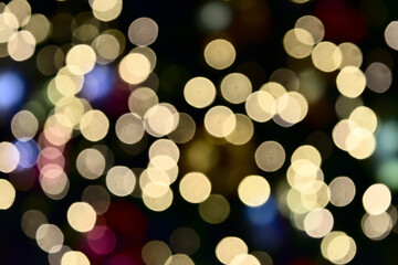 Bokeh from indoor lighting, Colorful light circles spread on purple with yellow with pink and orange color on black background for the celebration of the holiday season