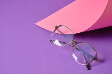 eyeglasses on pink and purple geometric background, trendy eyeglass frames copy space