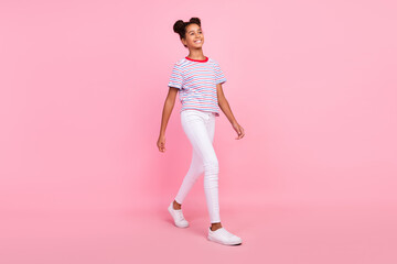 Full length photo of african american dreamy happy girl walk look empty space isolated on pink color background