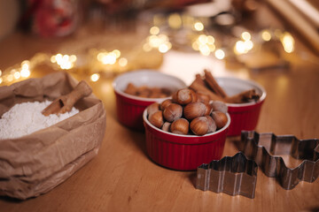 Home bakery, cooking traditional festive sweets. Preparing for making gingerbread dough on wooden table. New Year celebration traditions. Christmas mood. Nuts and flour