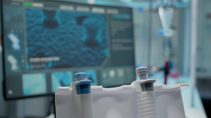 Close up of dna animation on computer and micropipette in scientific research laboratory. Empty...