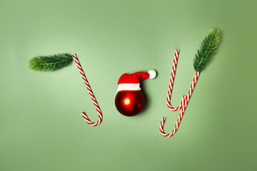 Joy word written with Christmas candy canes on green background. - Powered by Adobe