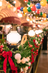Christmas decoration of restaurants and cafes. Christmas tree branches and red bows in the foreground. The interior is out of focus