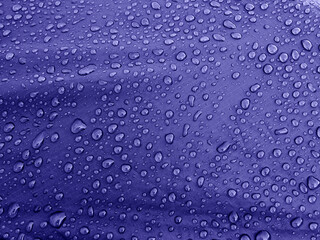 Water drops on waterproof membrane fabric. Morning dew on tent. Very Peri trend color 2022.