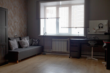 The interior of a teenage boy's room in dark gray and black colors