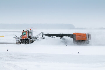 Snowblower cleans airport taxiway in a blizzard