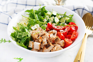 Grilled chicken fillet and fresh vegetable salad of lettuce, arugula, cucumber tomato and cheese. Healthy lunch menu. Diet food.