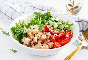 Grilled chicken fillet and fresh vegetable salad of lettuce, arugula, cucumber tomato and cheese. Healthy lunch menu. Diet food.