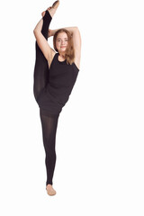 Fototapeta premium Sport Concepts. Full Length Portrait of Straight Caucasian Rhythmic Gymnast Sportswoman In Training Outfit During Her Split Legs Muscles Stretching Against White Background.