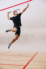Full-length portrait of sportive boy training, playing squash in sport studio - obrazy, fototapety, plakaty
