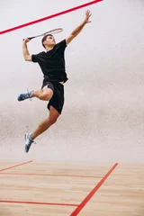 Zelfklevend Fotobehang Full-length portrait of sportive boy training, playing squash in sport studio © Lustre