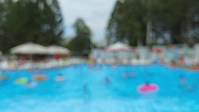 Blurred swimming pool. Blue color. Beach lockdown option. Stop motion video. H2O hotel relax. Water wave summer texture. Float calm splash. People poolside background. Unfocus vacation club