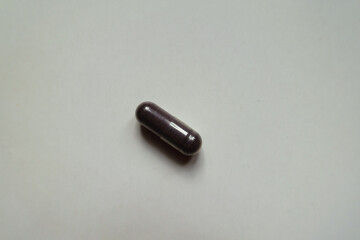 Naklejka premium One dark purple capsule of bilberry extract dietary supplement