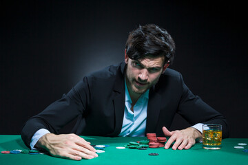 Nervous and Concentrated Handsome Caucasian Brunet Young Pocker Player At Pocker Table With Chips