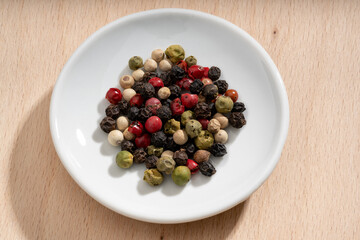 Detailed and large close up shot of peppercorns on a small plate