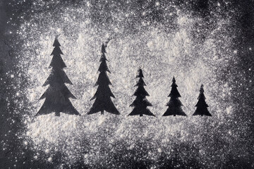 Traces from a stencil in the form of a Christmas tree from flour on a black concrete background....
