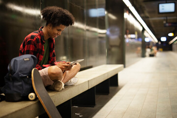 Young african man using tablet at the city. Handsome afro man in subway..