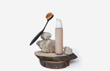 Foundation in a bottle and a cosmetic brush. Facial corrector on white background with copy space. 