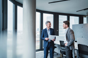 Smiling business people with document in meeting at office