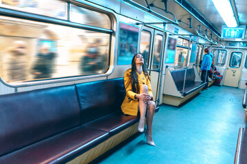 Stylish Lady in a Sexy Yellow Coat and Nude Shoes Sits on a Seat with Crossed Legs in an Empty...