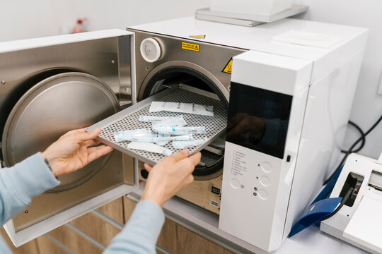 Dentist cleaning equipment in autoclave at clinic