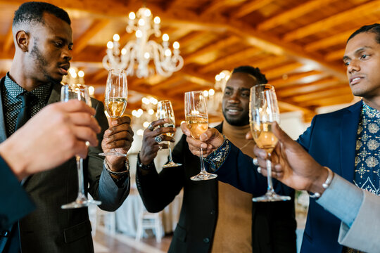 Male friends toasting champagne at banquet