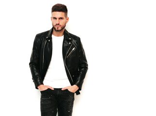 Portrait of handsome confident lambersexual model. Sexy stylish man dressed in biker leather jacket and black jeans. Fashion hipster male isolated on white in studio