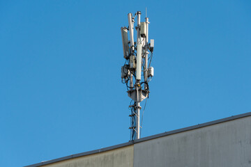 Obraz premium New GSM antennas on the roof of a building for transmitting a 5g signal are dangerous to health. Radiation pollution of the environment through cell towers. The threat of extinction of the population