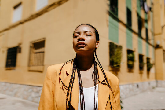 Woman with braided hair standing during sunny day in city