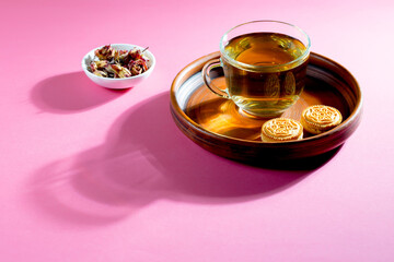 Tea in a cup in a composition with pastries and dessert, on a bright colored background.