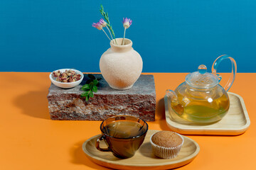 Tea in a cup in a composition with pastries and dessert, on a bright colored background.