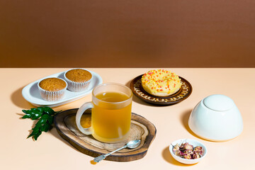 Tea in a cup in a composition with pastries and dessert, on a bright colored background.