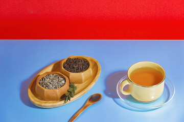 Tea in a cup in a composition with pastries and dessert, on a bright colored background.