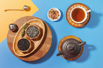 Tea in a cup in a composition with pastries and dessert, on a bright colored background.