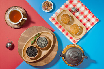 Tea in a cup in a composition with pastries and dessert, on a bright colored background.