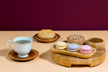 Coffee in a cup in a composition with dessert, on a bright, colorful background.