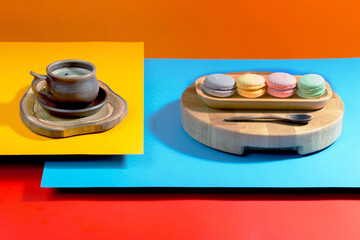 Coffee in a cup in a composition with dessert, on a bright, colorful background.