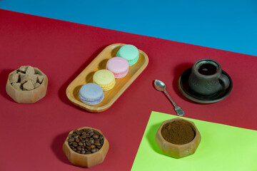 Coffee in a cup in a composition with dessert, on a bright, colorful background.