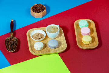 Coffee in a cup in a composition with dessert, on a bright, colorful background.