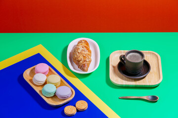 Coffee in a cup in a composition with dessert, on a bright, colorful background.