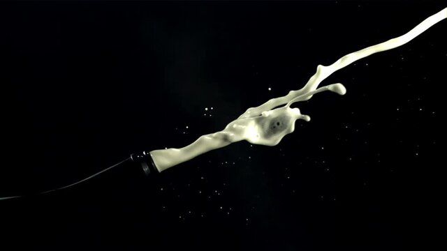 A bottle of champagne shoots a jet of air bubbles. On a black background. Filmed is slow motion 1000 fps.