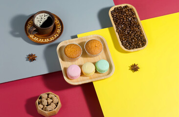 Coffee in a cup in a composition with pastries and dessert, on a bright colored background.